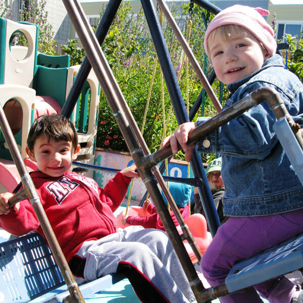Untitled Children smiling on the outdoor swings