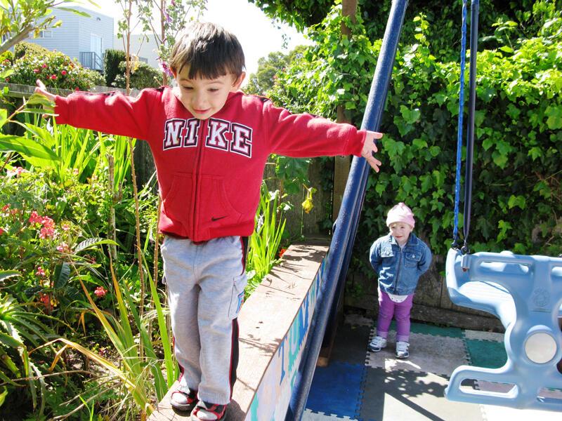 Children smiling on the outdoor swings