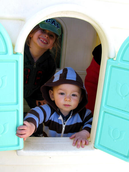 Children riding toy cars in the outdoor play area
