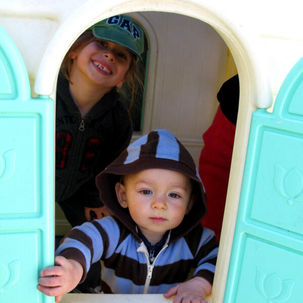 Untitled Children playing inside an outdoor playhouse