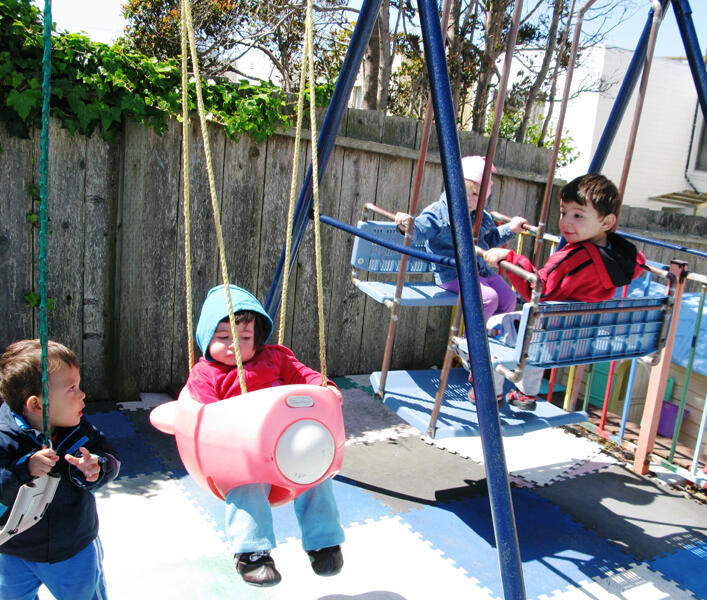 Children enjoying swings in the backyard playground
