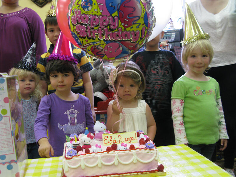 Untitled Child celebrating a 2nd birthday with cake and gifts