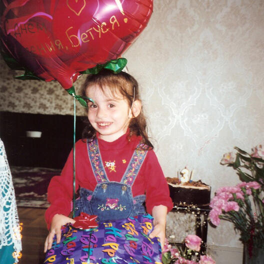 Untitled Child smiling with birthday balloon and gift