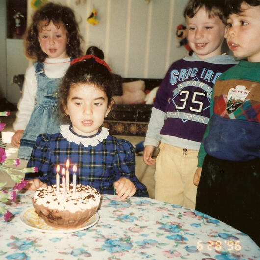 Child celebrating a birthday with cake and friends