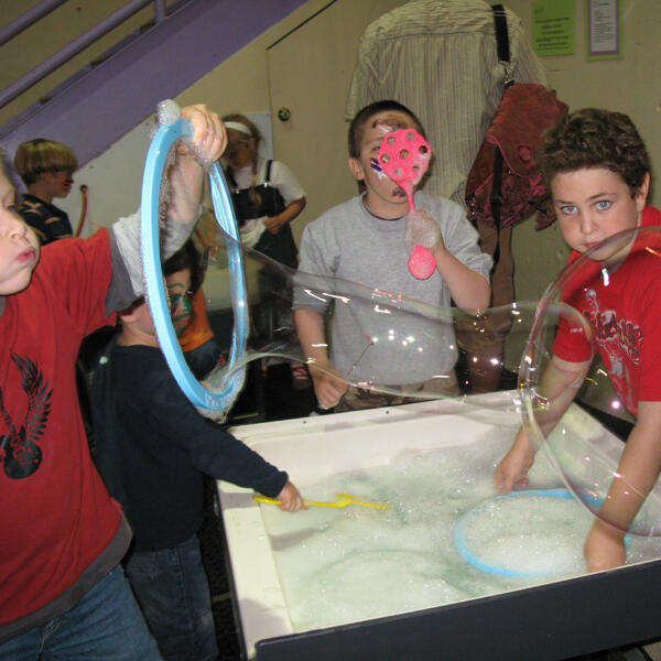 Untitled Children playing with bubbles during a museum visit