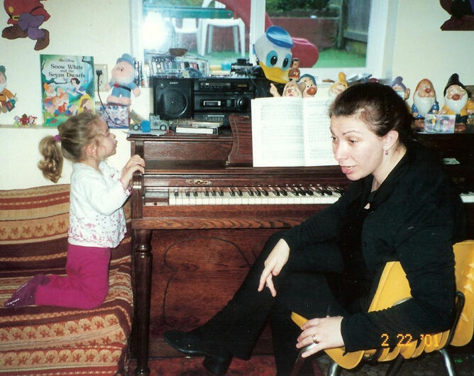 Lana helping a child with writing practice at her San Francisco preschool.