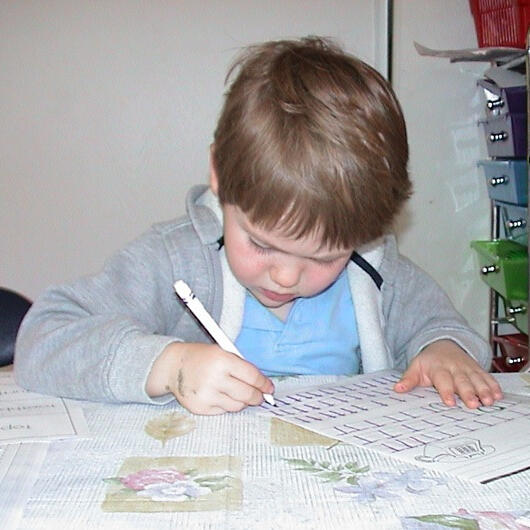 Child practicing writing at the table