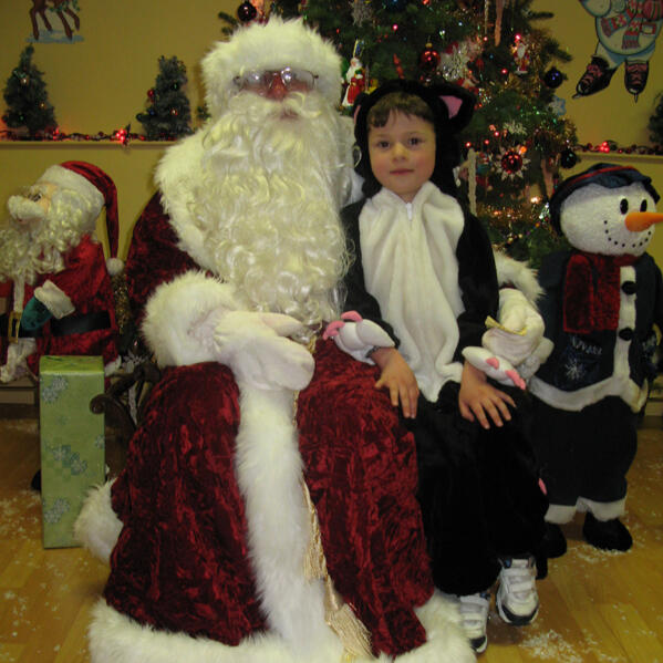 Child in costume with Santa during a holiday celebration